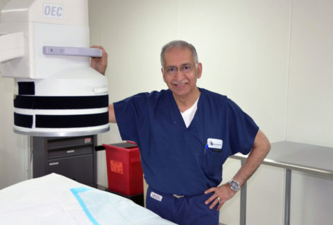 Dr. Saqib Chaudhry standing next to machine