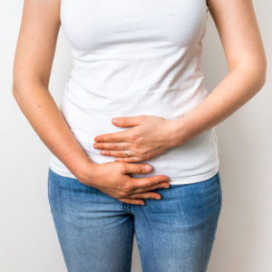 woman holding stomach wondering do i have fibroids