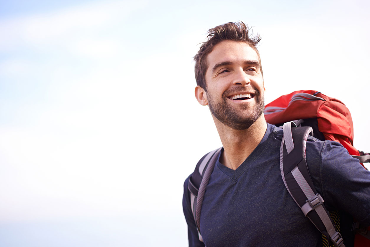 Man smiling with a backpack on