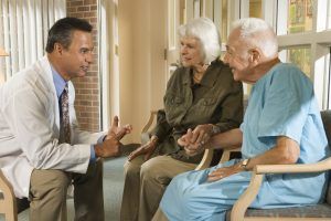 Doctor talking with elderly couple