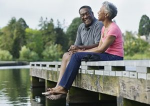 Elderly couple sitting together on a pier