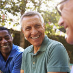 Mature Male Friends Socializing In Backyard Together