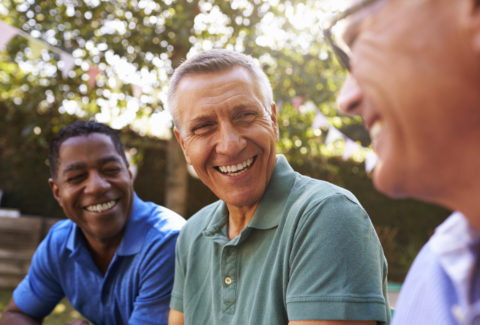 Mature Male Friends Socializing In Backyard Together