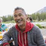 Man smiling at picnic table at campsite