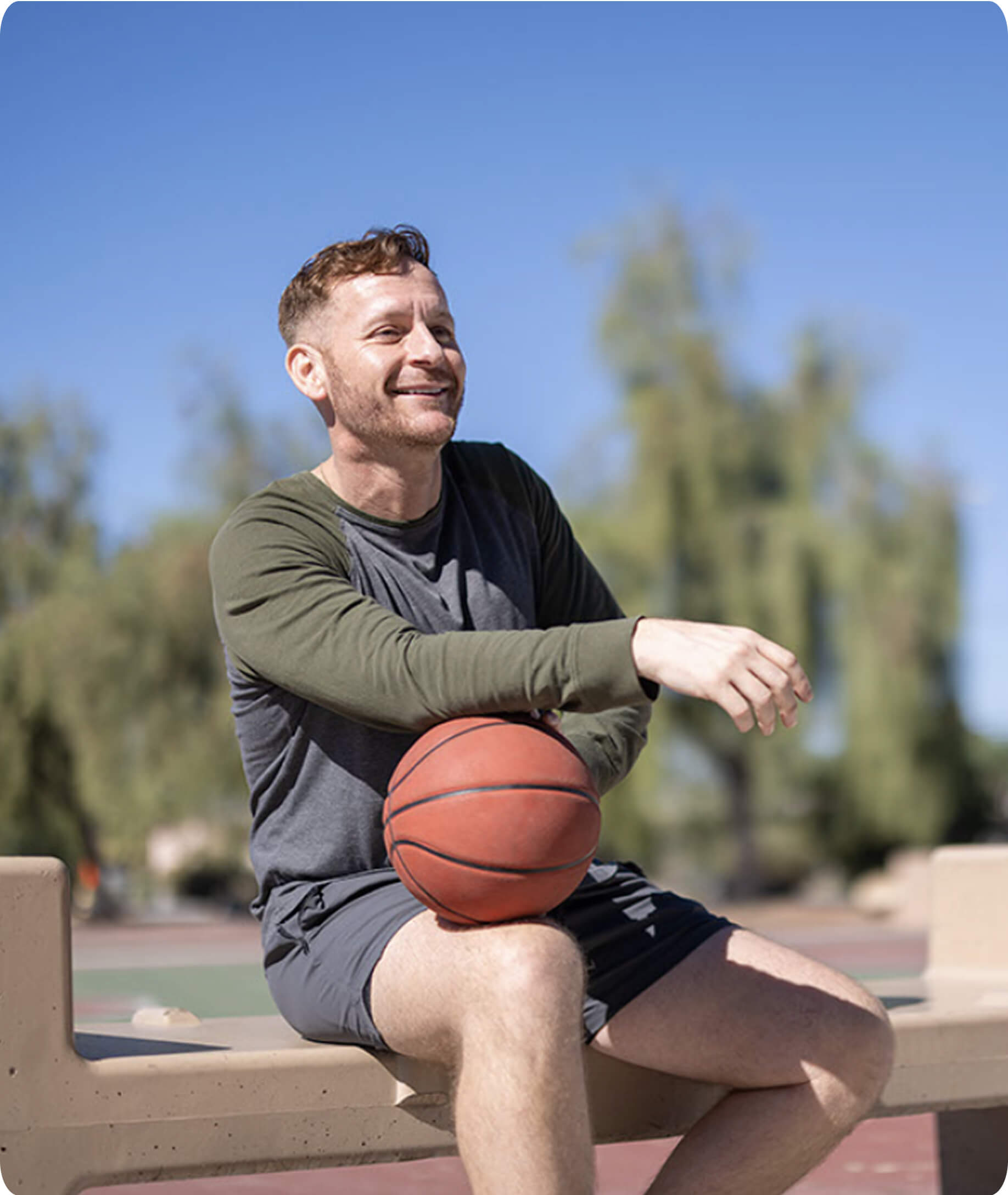 A man with a basketball after a varicocele embolization procedure