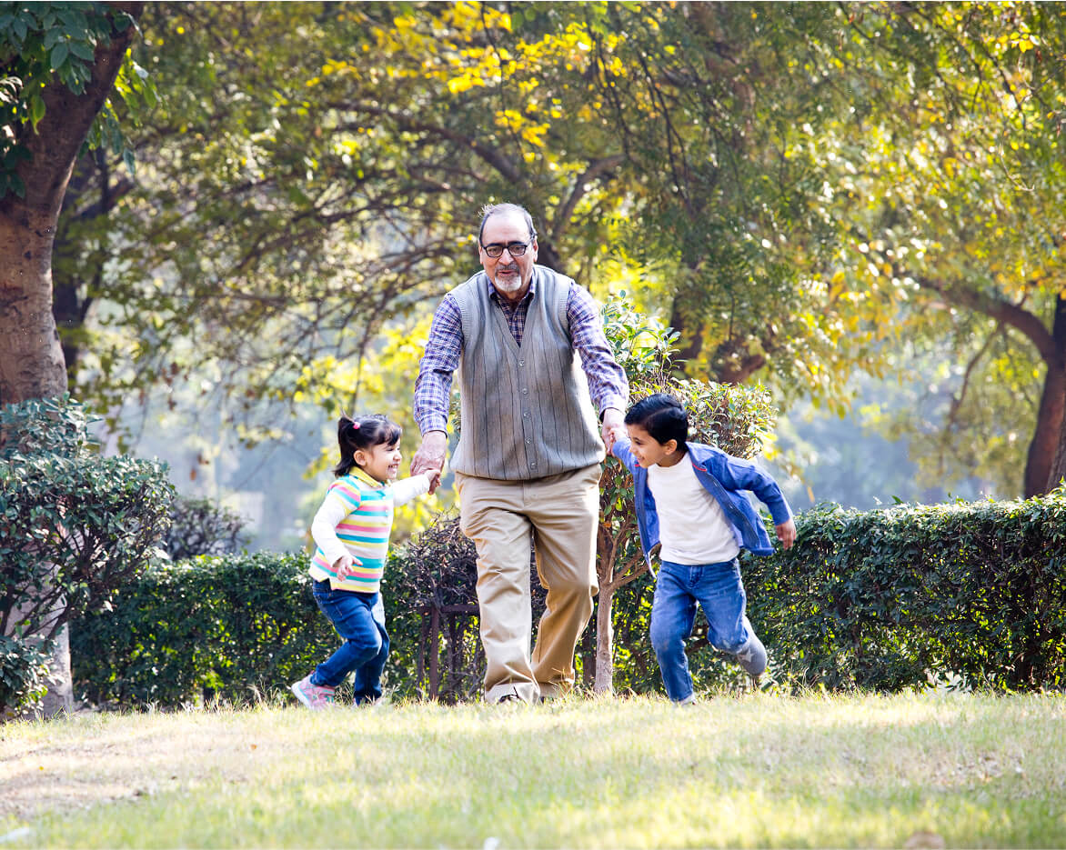 A man at the park with two children after a kyphoplasty or vertebroplasty procedure.